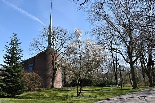 Kirche auf dem Gelände der LWL-Klinik Münster, blauer Himmel und Bäume vor der Kirche